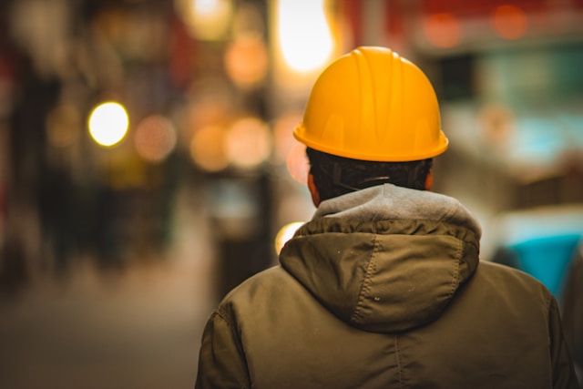 rear view of worker in yellow hardhat and jacket