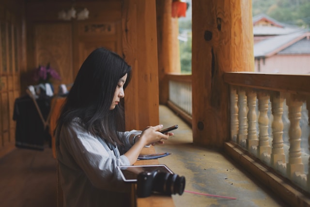 side view of pretty chinese woman holding phone