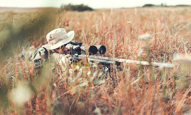 hunter with rifle in weeds