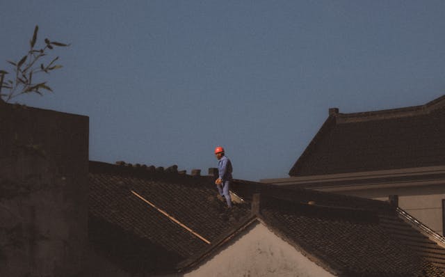 construction worker with red hardhat on roof