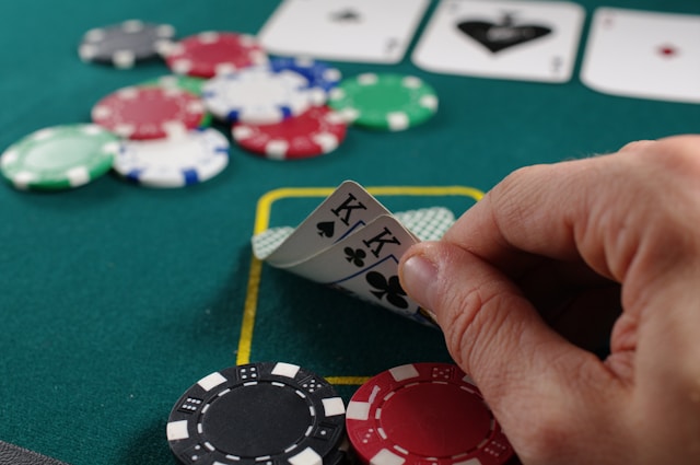 cloesup of hand of two kings on table with chips for poker