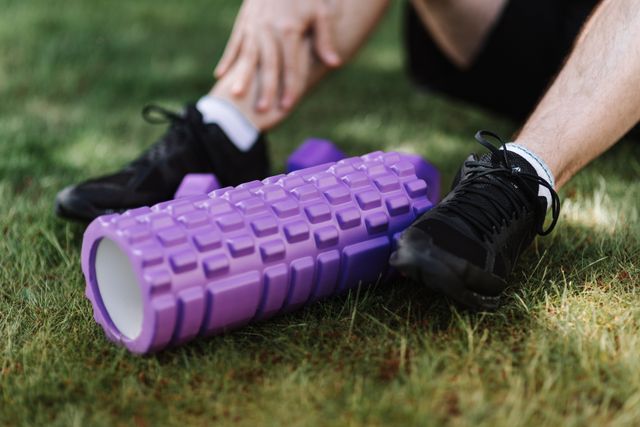 close-up of man's sneekers in grass next to roller