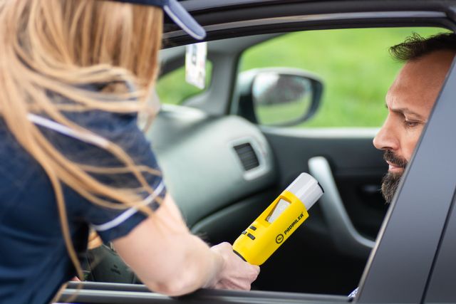 breathalyzer test on man in car