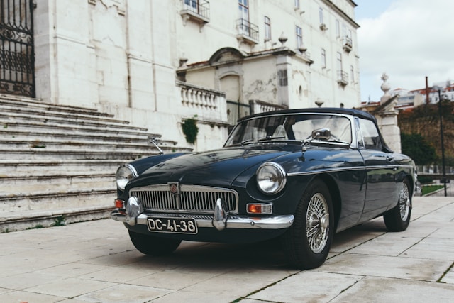 classic car next to stairs of old stone building