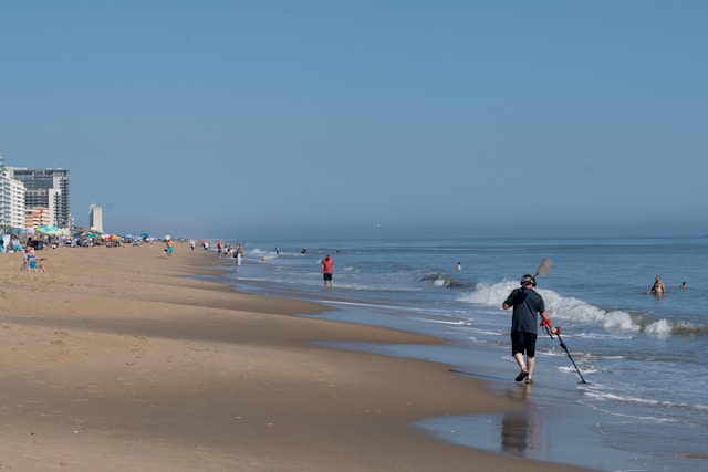 man with metal detector on beach