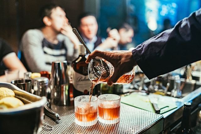 close-up of bartender hand pouring a cocktail