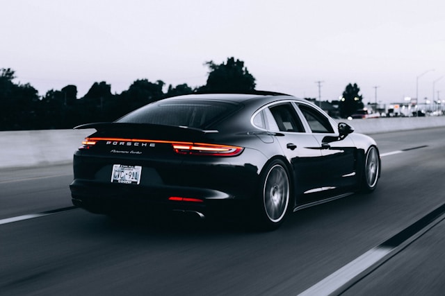 Porsche sedan on the road rear angle view
