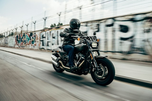 man in helmet riding motorcycle at high speed