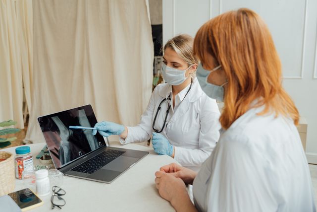 doctors reviewing x-ray on laptop