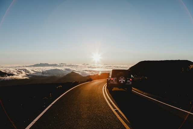 rear view of jeep on road at dusk