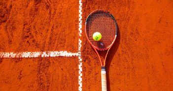 tennis racket and ball on clay court