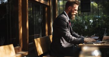 man with beard using laptop