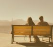 rear view of woman and man sitting on bench with vintage feel
