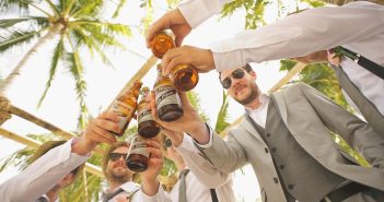 men doing a teast with beer bottles