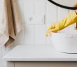person with gloves cleaning bathroom