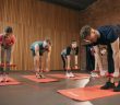 people in workout group with dumbells and matts