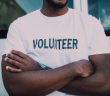 man in white shirt that spells out volunteer