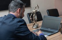 Top Benefits of Hiring a Migration Agent man working at desk with laptop rear angle view