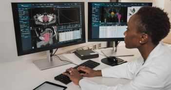 person on computer with multiple screens