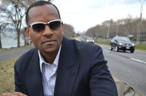 black man with shirt afro hair in sunglasses and blazer and blue shirt