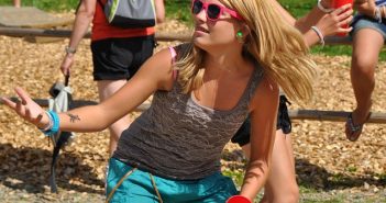 pretty blonde woman playing sport outside in tank top and blue pants