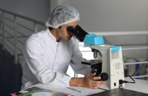 researcher in a lab looking into microscope