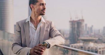 man in blazer looking over balcony