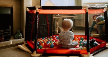 toddler in playpen view from behind