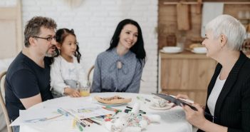 man woman and child around table with social worker