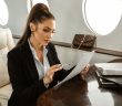 attractive brunette woman in business suit review paper on private jet