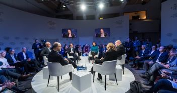 people around table on stage at a conference