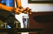 glass on table with man's hands over it