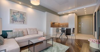 living room with light couch and green patterned rug