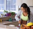 pretty brunette woman with caramel skin in shirt and lime green tank top slicing veggies in kitchen