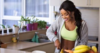 pretty brunette woman with caramel skin in shirt and lime green tank top slicing veggies in kitchen