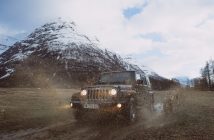 Jeep on road in cold weather near white capped mountain