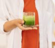green smoothie in glass held in hand
