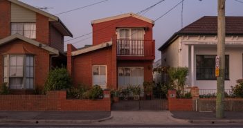 small house on street with electricity pole and ines