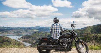 man sitting on with back turned harley davidson motorcycle