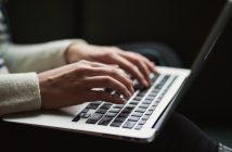 closeup of woman's hand on laptop keyboard