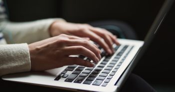 closeup of woman's hand on laptop keyboard