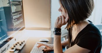 side view of attractive woman using desktop comuter at desk