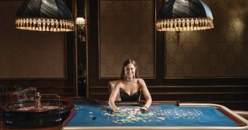 woman sitting next to gaming table in casino