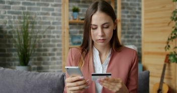 pretty woman with long brown hair using credit card to make purchase