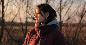 attractive brunette woman in red coat outside
