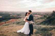 bride and groom embracing outdoors in a field