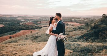 bride and groom embracing outdoors in a field