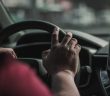 person's hand on car steering wheel