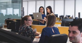 people working on computers at desks in office