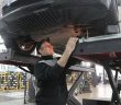 mechanic working on engine standing under vehiccle
